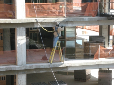Worker on building with safety harness & lifeline