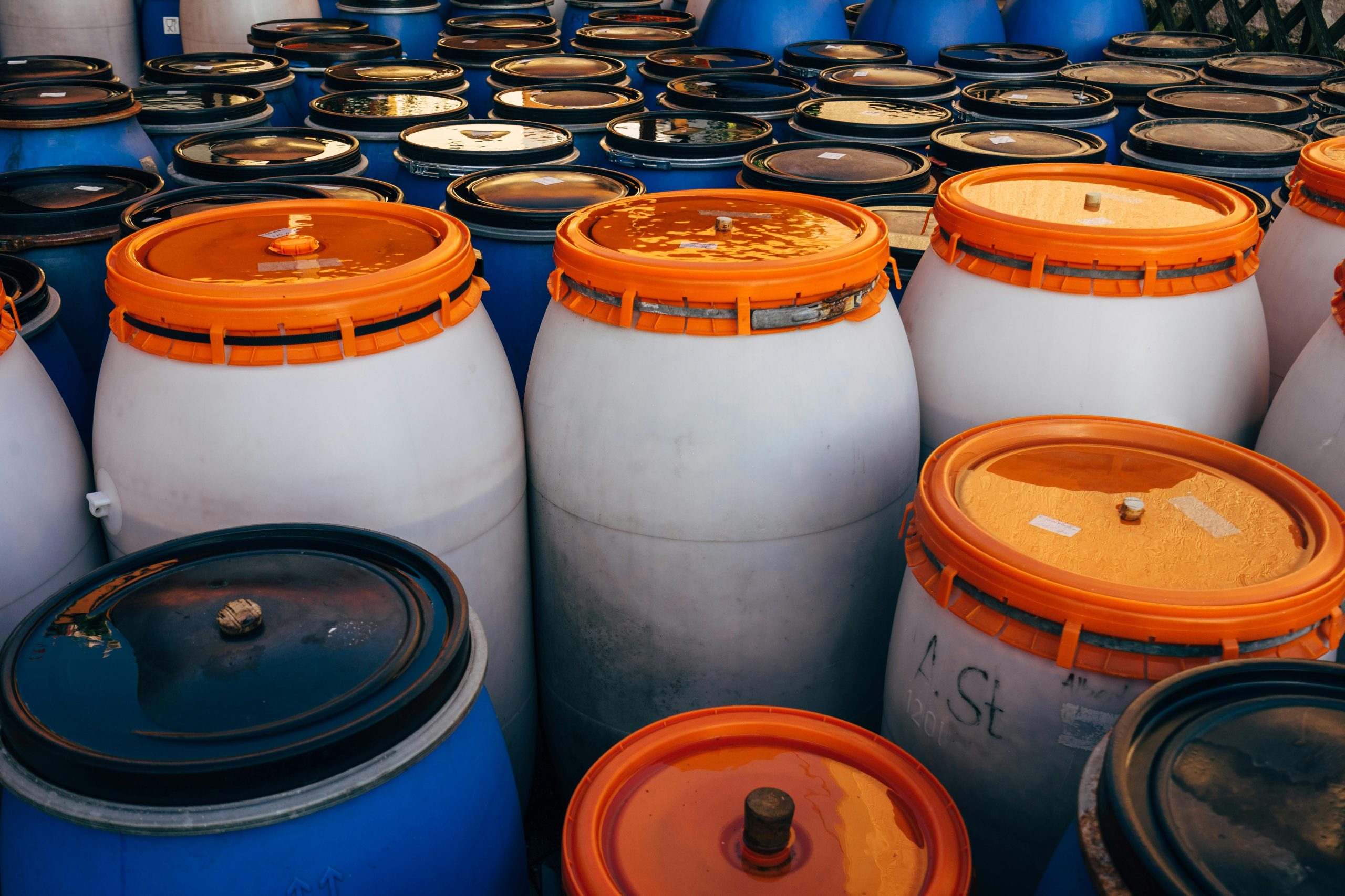 Close-up of plastic chemical storage barrels in an industrial facility